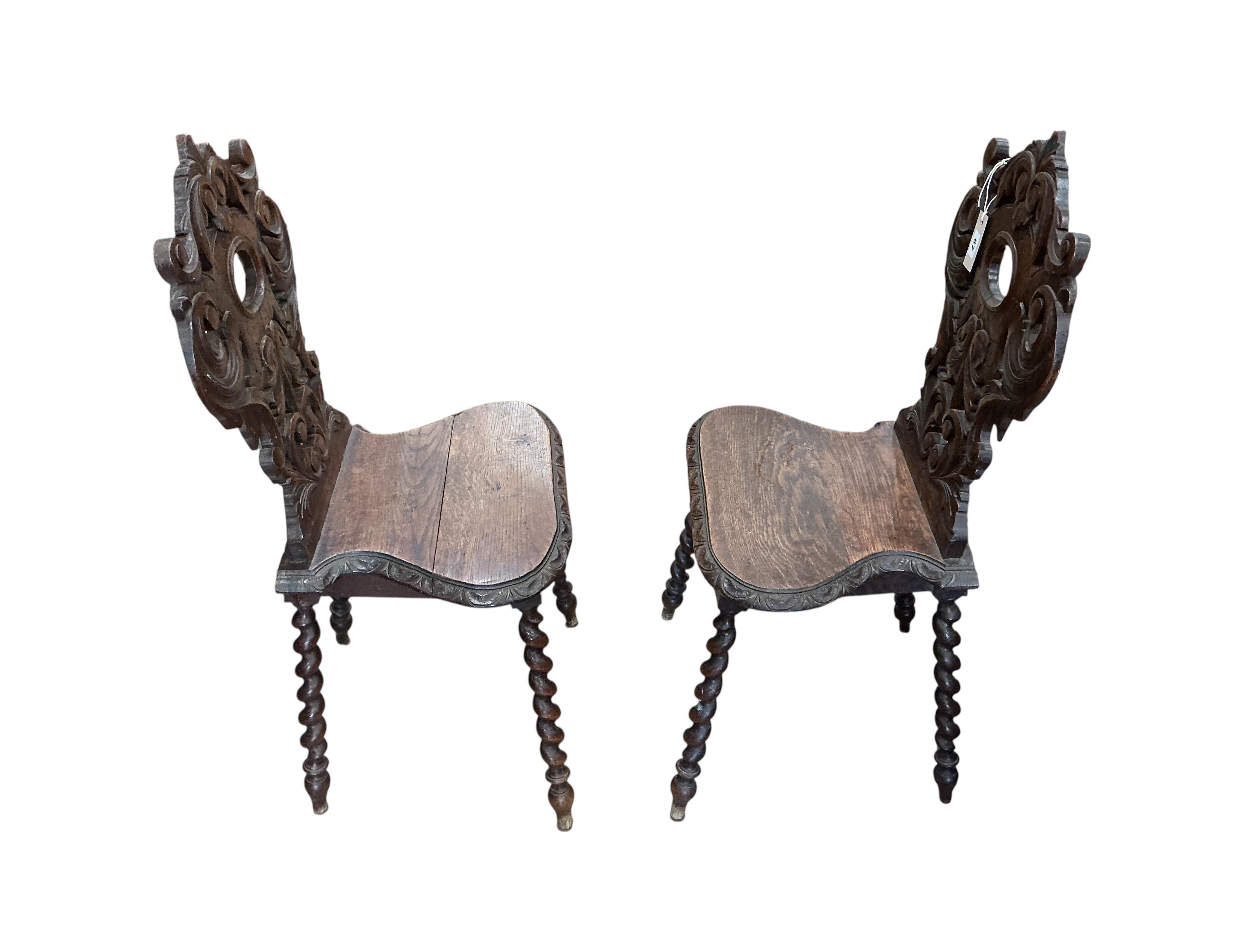 A pair of 19th century carved oak hall chairs, width 45cm, depth 34cm, height 94cm